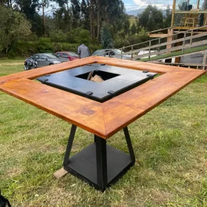 sador al corbon con mesa de madera cuadrada con un agujero cuadrado en el medio.